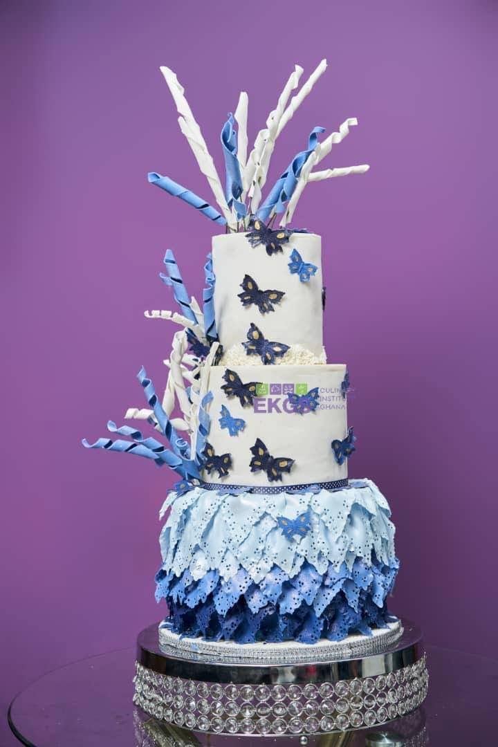 Three-tier cake with blue sugar butterflies, ruffled petals and twisted sugar ribbons