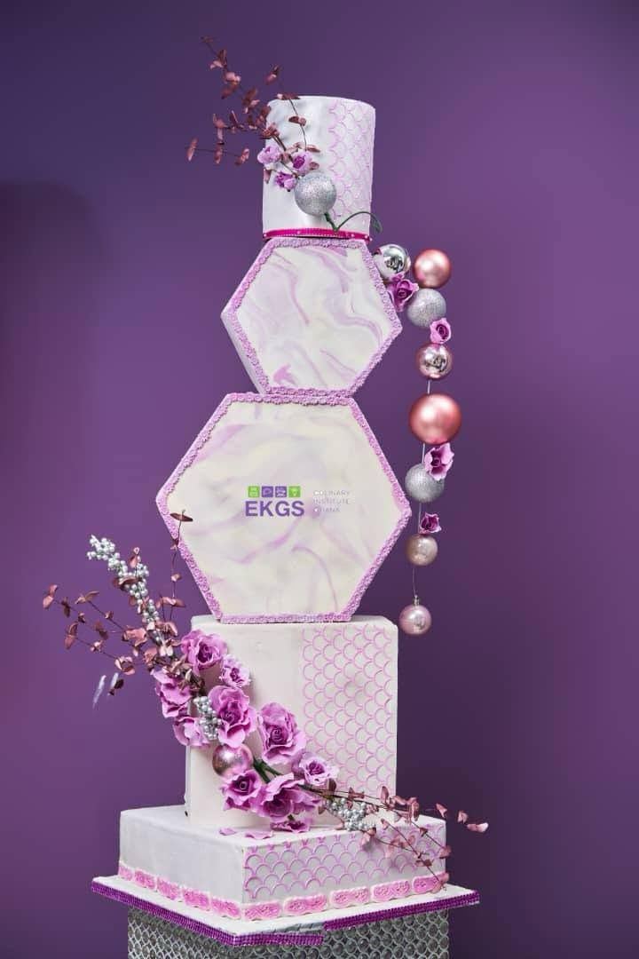 Five-tier cake with lilac marbled hexagon tiers, sugar roses and pearl baubles