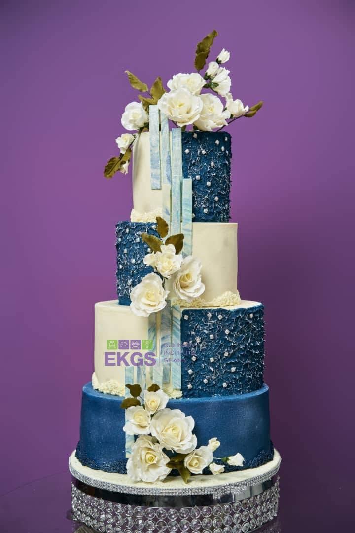 Four-tier navy and ivory cake with cascading white sugar roses
