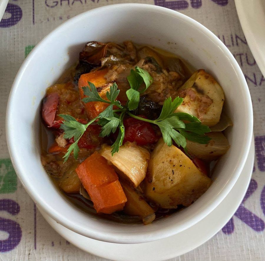 Bowl of vegetable stew with carrots and potatoes, garnished with parsley
