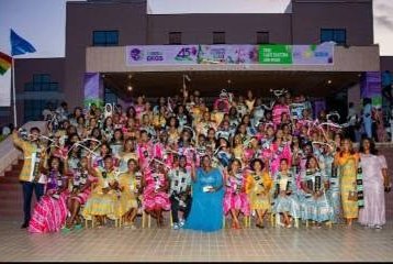 Graduating class in colourful dresses in front of the EKGS campus