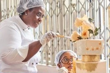 Instructor finishing a gold cake with sugar roses