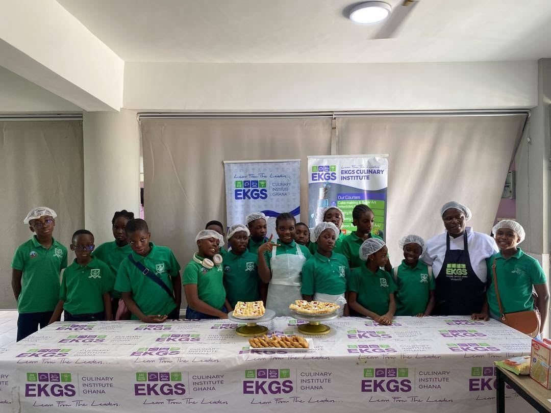 Pupils in green uniforms with an EKGS instructor and the pastries they baked